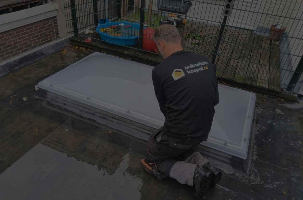 Monteur werkt aan een rechthoekige opale lichtkoepel op het platte dak van een woning